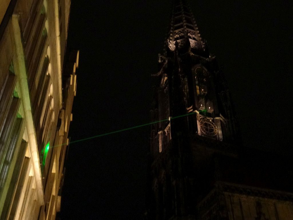 gegenwaertig. Grüner Laserstrahl, Verbindungslinie zwischen dem ehemal. Wohnhaus des Täufer-Führers Bernd Knipperdolling mit seinem „Grab“, einem der Käfige am St.-Lamberti-Kirchturm. Anl. 350 Jahre Westfäl. Frieden 2017